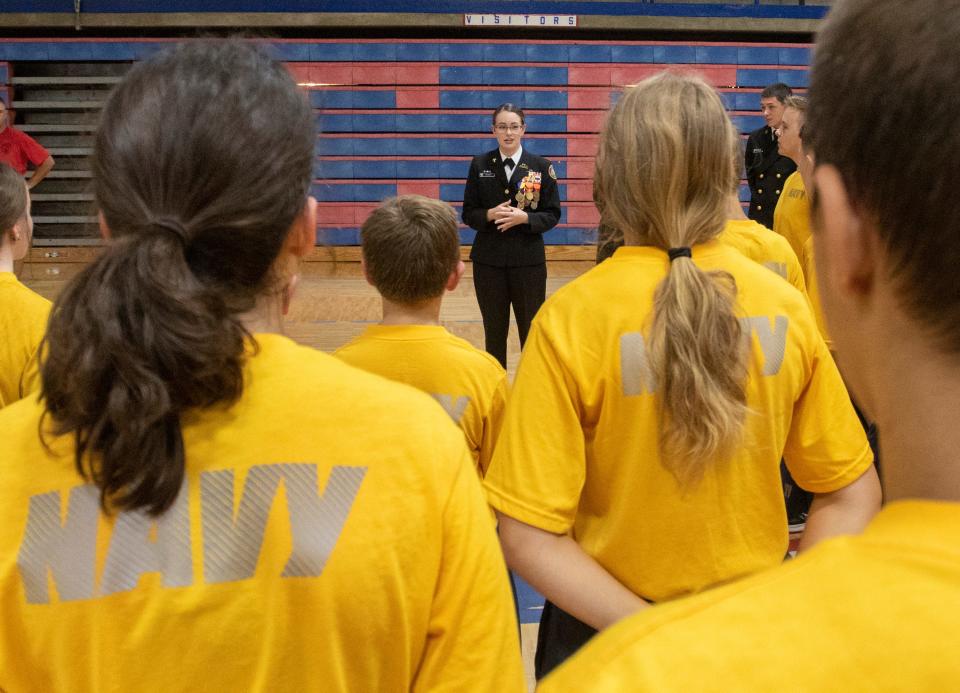 Command Master Chief Madeline Grady, 16, top center, talks with her fellow Navy JROTC cadets following physical training at Pace High School on Friday.