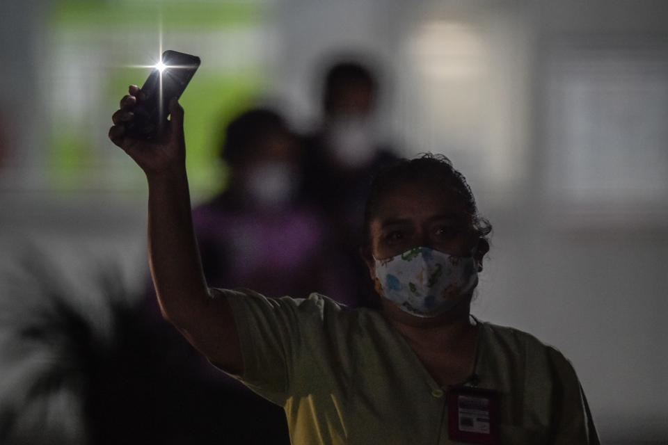 Medical personnel from the "20 de Noviembre" hospital wave back to residents across the street singing to praise them and their patients in Mexico City, on April 28, 2020, amid the novel coronavirus pandemic. - Latin America is like "Europe six weeks ago" in relation to the advance of COVID-19, so an increase in the number of cases is expected in the coming weeks, warned on April 28 the deputy director of the Pan American Health Organization (PAHO), Jarbas Barbosa. (Photo by PEDRO PARDO / AFP) (Photo by PEDRO PARDO/AFP via Getty Images)