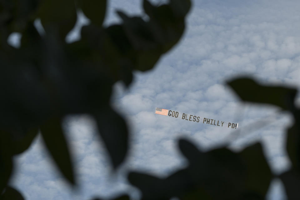 An airplane flies a banner reading 'God bless Philly PD' at the Cathedral Basilica of Saints Peter and Paul in Philadelphia, Tuesday, Oct. 24, 2023. Officer Richard Mendez was shot and killed, and a second officer was wounded when they confronted people breaking into a car at Philadelphia International Airport, on Oct. 12, police said. (AP Photo/Joe Lamberti)