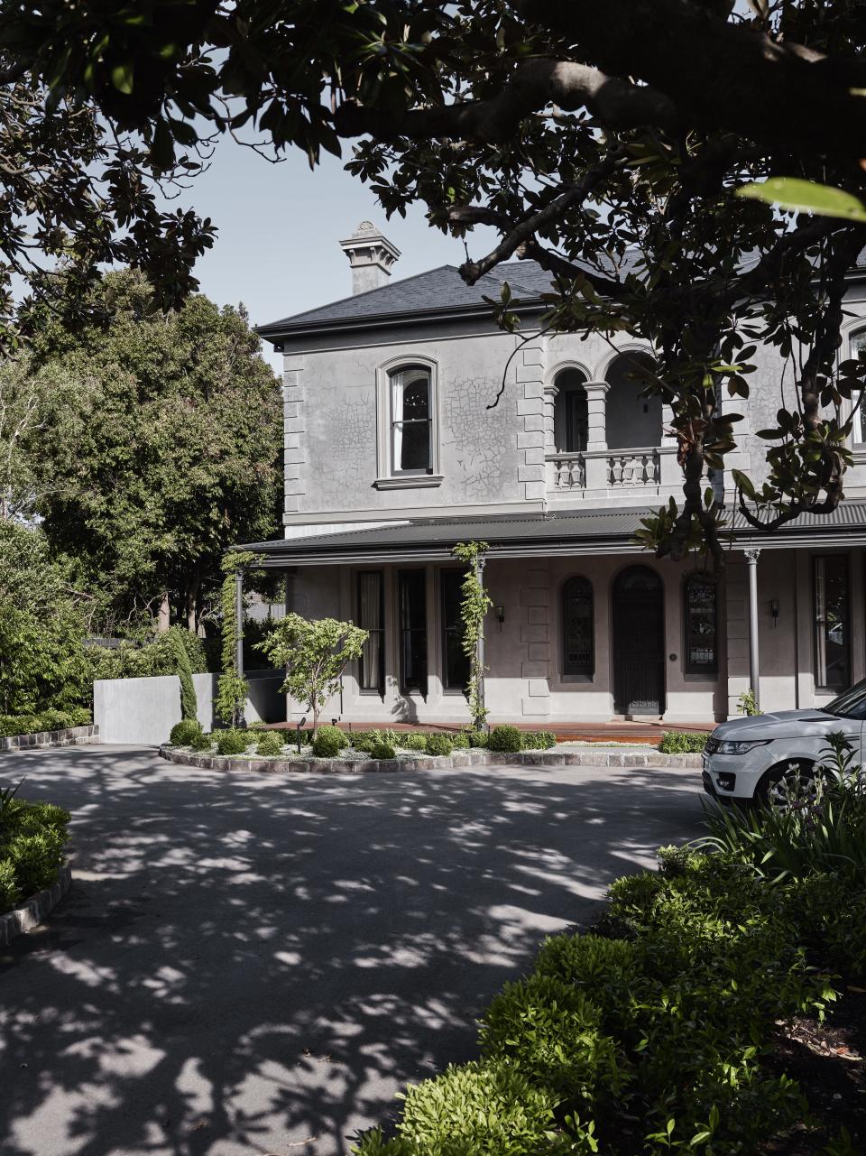 Driveway with mature trees and traditional house