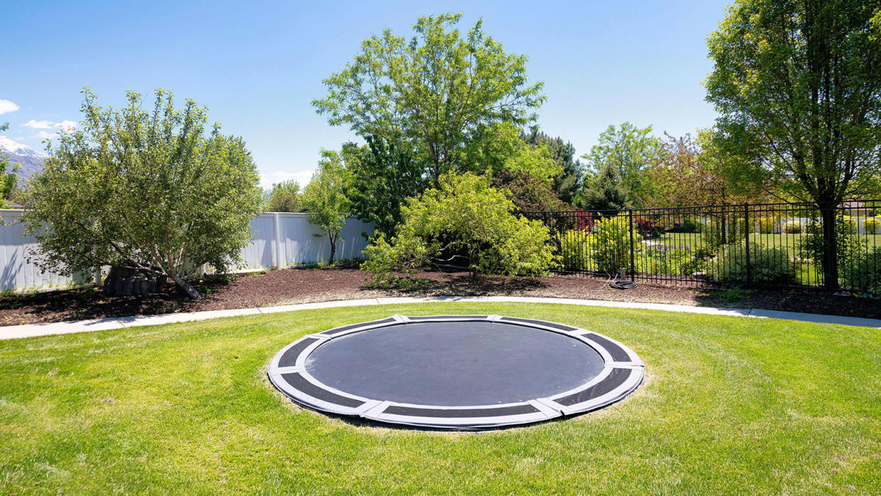  in-ground trampoline in the middle of a lawn 