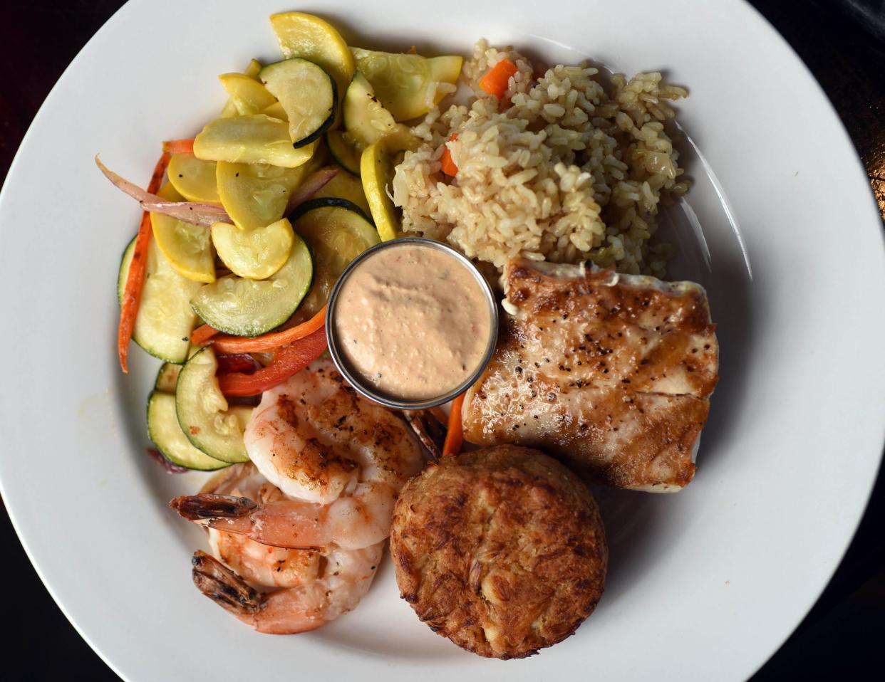 The chef's trio at the Bridge Tender Restaurant features grilled shrimp, grilled mahi and crab cake in Wilmington, N.C. The well-known restaurant opened in 1976 and overlooks the Intracoastal Waterway. MATT BORN/STARNEWS