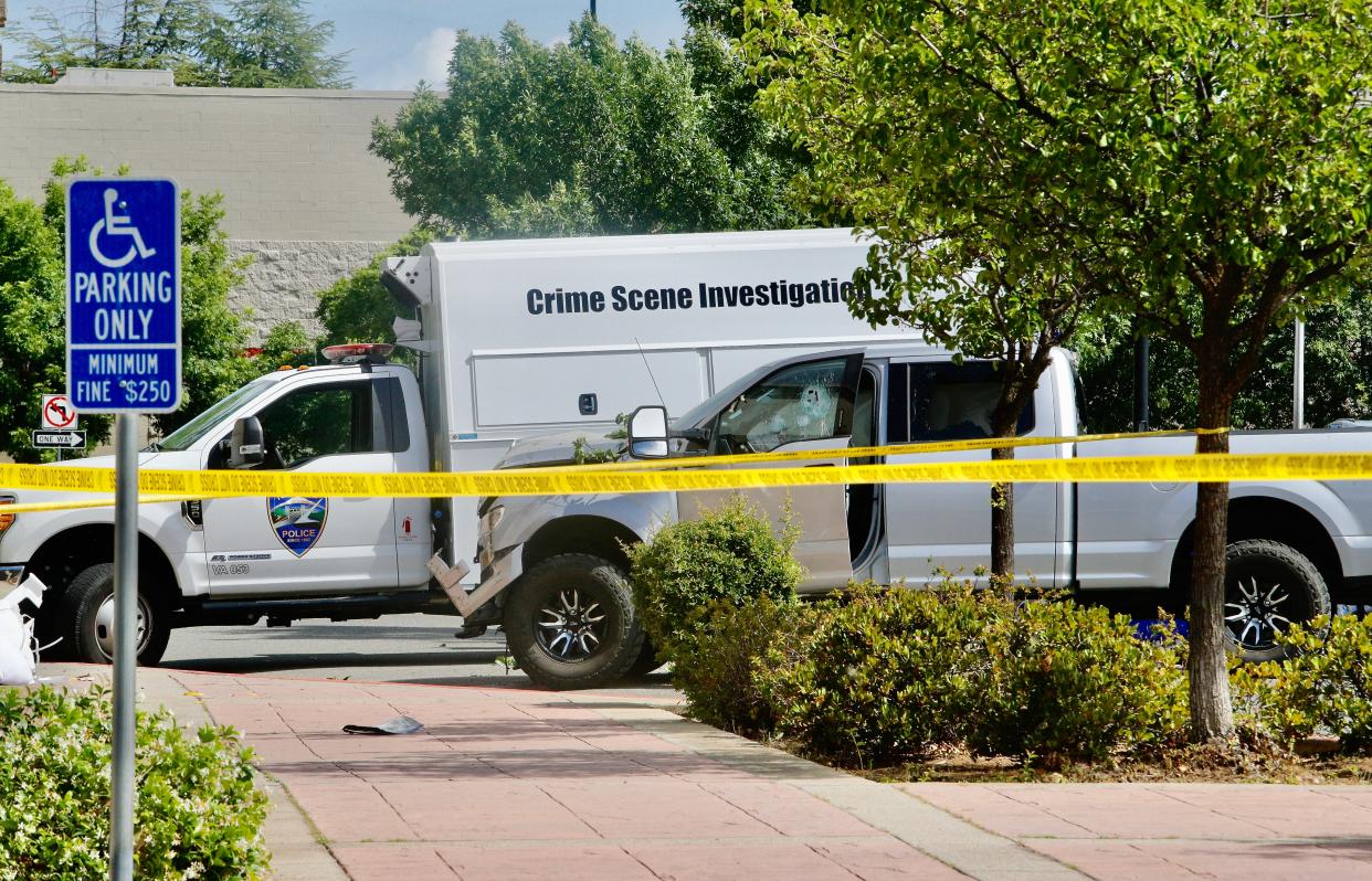 A crime scene investigation van is parked next to a pickup where a man crashed into the side of Ashley Furniture and was found dead by Redding police on Saturday morning, May 28, 2022.
