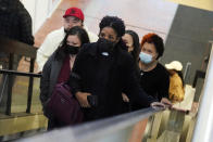 CORRECTS FIRST NAME TO DAMIK INSTEAD OF DARNIK - The family of Daunte Wright, led by his mother Katie, second from left, a clergy member, front center, and son Damik, at left with red cap, arrive Tuesday, Nov. 30, 2021, at the Government Center in Minneapolis where jury selection begins for former suburban Minneapolis police officer Kim Potter, who says she meant to grab her Taser instead of her handgun when she shot and killed motorist Daunte Wright. (AP Photo/Jim Mone)