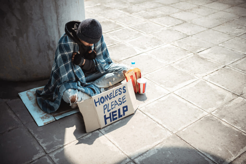 One man, young homeless sitting on the street and begging.