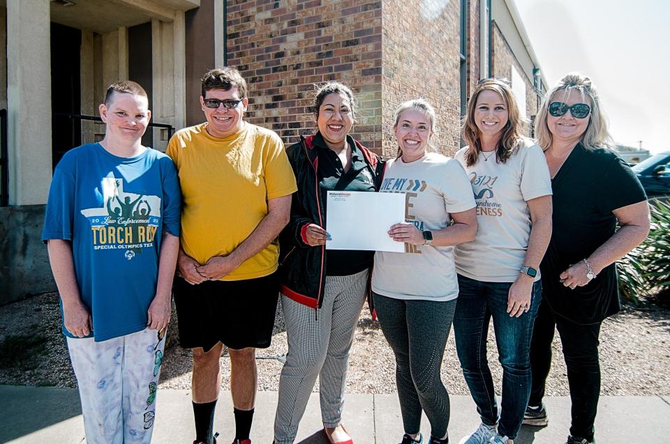 Representatives from North Texas Special Olympics receive donations March 25 from Midwest Dental and Empire Paper. The companies raised funds in honor of World Down Syndrome Day.