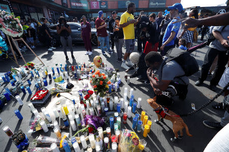 People light candles by a makeshift memorial for Grammy-nominated rapper Nipsey Hussle who was shot and killed outside his clothing store in Los Angeles, California, U.S., April 1, 2019. REUTERS/Mario Anzuoni