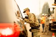 An Army National Guard specialist works at a checkpoint as the Carr Fire burns in Redding, Calif., on July 28, 2018. Thousands of residents were evacuated as the blaze threatened homes in Redding and surrounding communities.