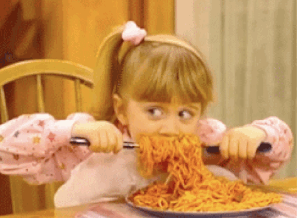 A girl eating lots of spaghetti