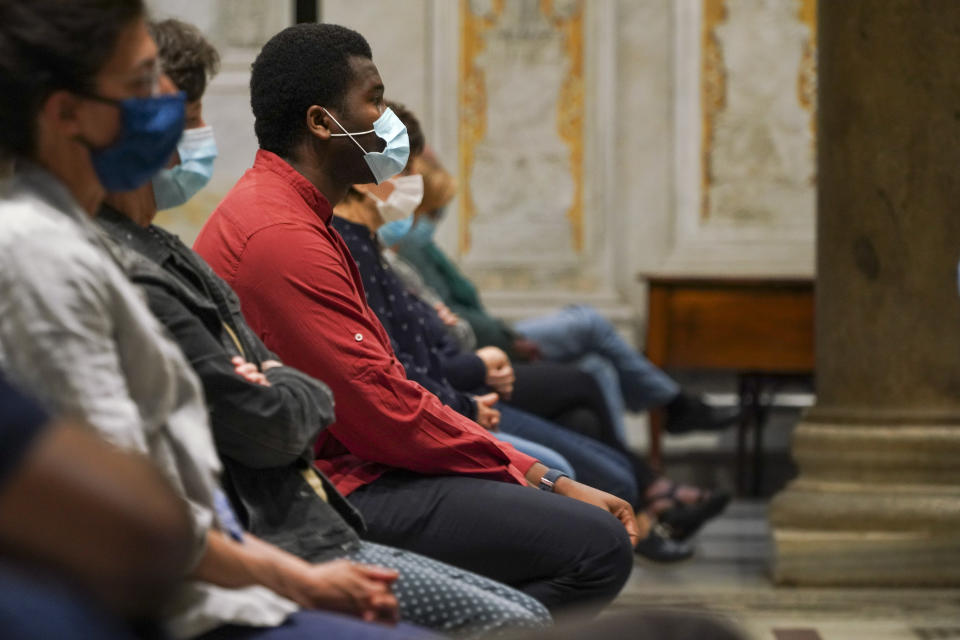 Faithful wearing face mask to prevent the spread of COVID-19 attend a vigil prayer lead by US Cardinal Kevin Joseph Farrell over the death of George Floyd, a black man who died after being restrained by Minneapolis police officers on May 25, in Rome's Santa Maria in Trastevere church, Friday, June 5, 2020. Cardinal Farrell says the killing of George Floyd has laid bare that the Christian principles of the U.S. Constitution aren’t being applied to blacks, and is evidence that divisive, demonizing language can kill. (AP Photo/Andrew Medichini)