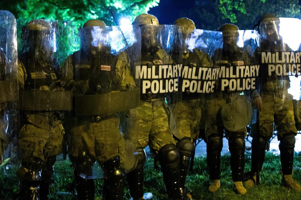 Military police officers watch demonstrators as they chant outside of the White House on May 30 in Washington, D.C., during a protest over Floyd's death. (Photo: JOSE LUIS MAGANA via Getty Images)