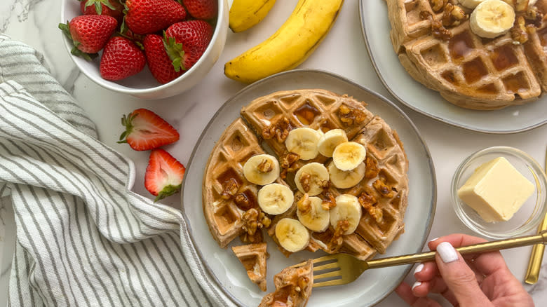 hand with waffle and fruit