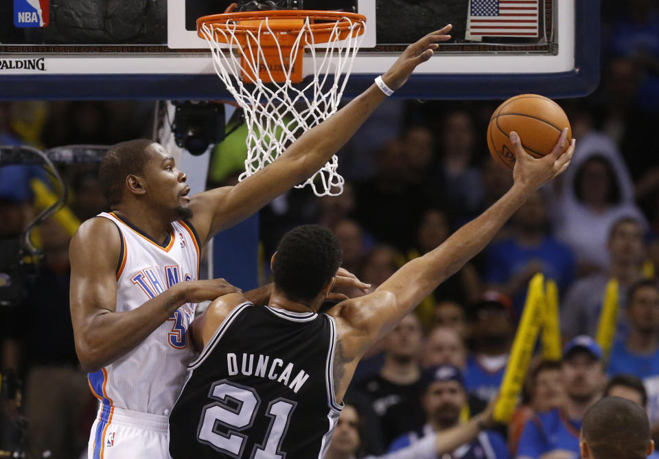 Oklahoma City Thunder forward Kevin Durant (35) attempts to block a shot by San Antonio Spurs forward Tim Duncan (21) in the second quarter of an NBA basketball game in Oklahoma City, Thursday, April 3, 2014. (AP Photo/Sue Ogrocki)
