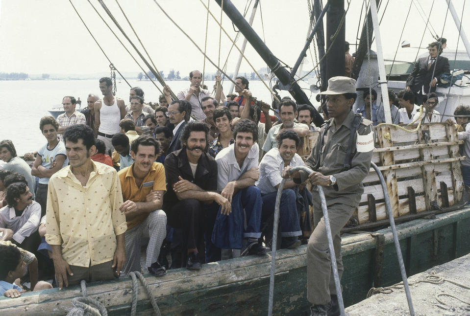 FILE - A Cuban soldier stands by a refugee ship at the small port of Mariel, Cuba on April 23, 1980, as the refugees aboard wait to sail for U.S., where they hope to start new lives. Cuban President Fidel Castro agreed to let the Cubans leave the communist island aboard boats that would take them to Florida. The Immigration and Nationality Act of 1952 lets the president grant entry for humanitarian reasons and matters of public interest. Previous administrations have admitted large numbers of Hungarians, Vietnamese and Cubans. (AP Photo/Jaques Langevin, File)