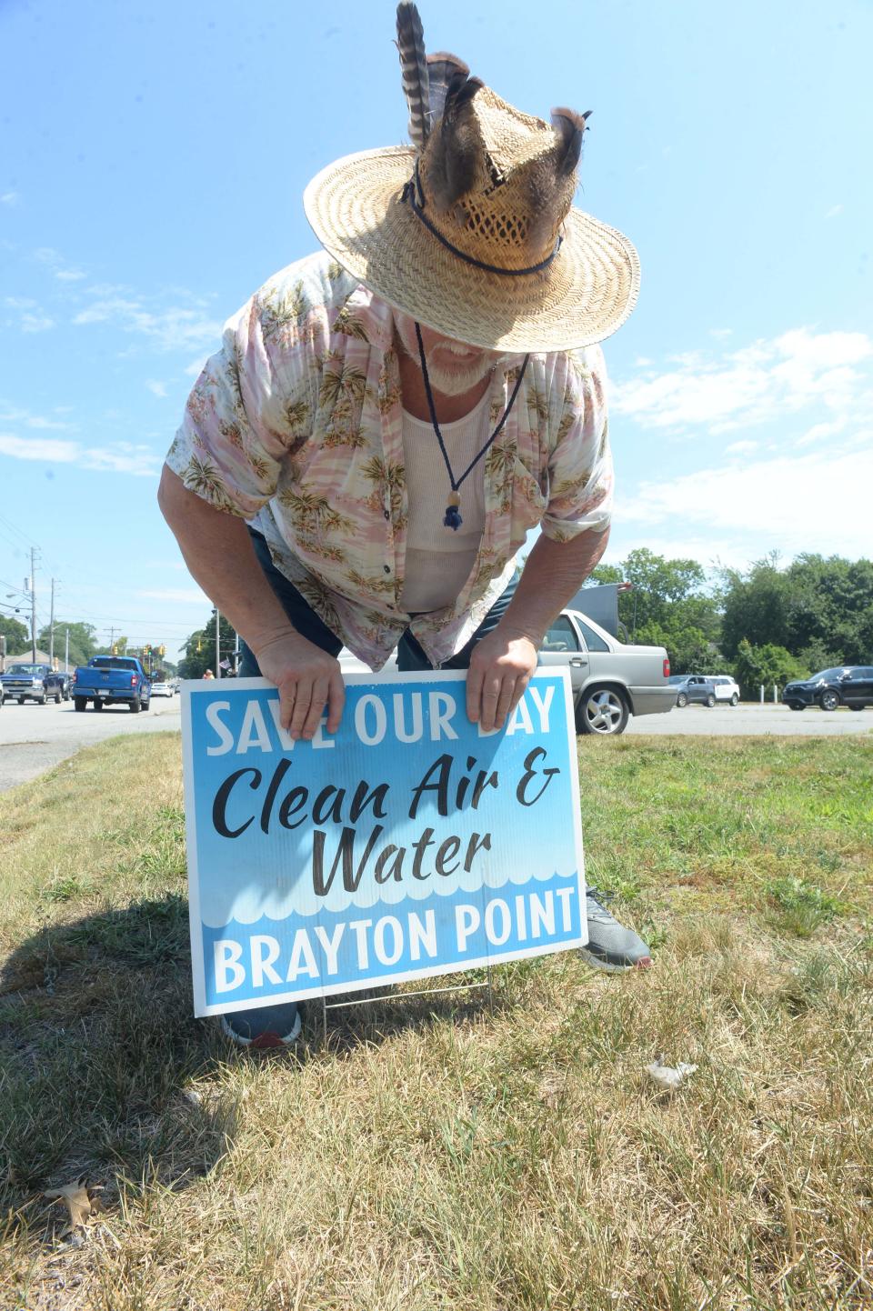 Jonathan McCarthy of Swansea plants this sign along Brayton Point Road for the visit of President Joe Biden speaks who spoke at Brayton Point Commerce Center in Somerset on Wednesday, July 20, 2022.