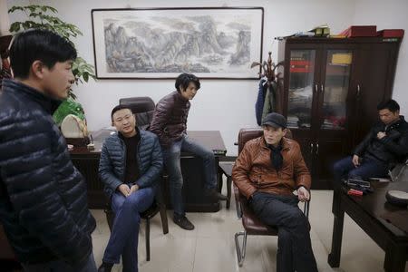 Migrant workers pass time at the offices of a subcontractor company at the construction site of Zixia Garden development complex in Qianan, Tangshan City, Hebei province, China January 28, 2016. REUTERS/Damir Sagolj