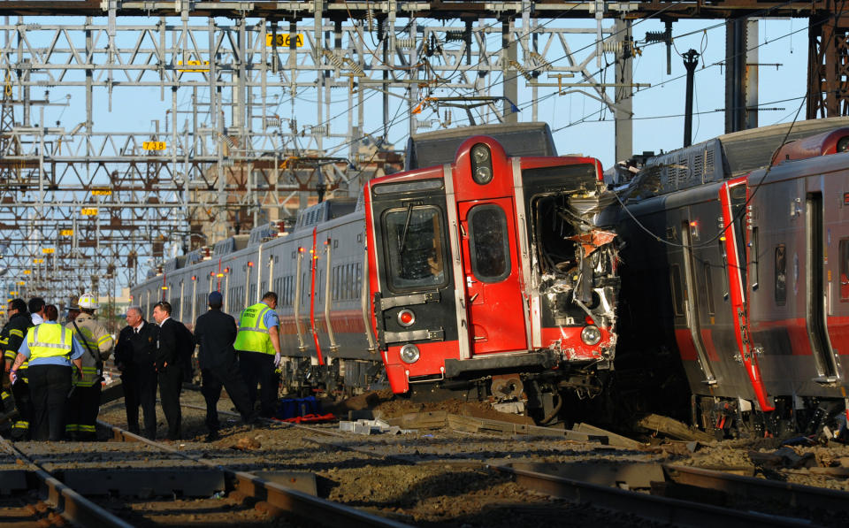 FILE - In this May 17, 2013 file photo, emergency workers arrive at the scene of a train collision in Fairfield, Conn, after two Metro-North commuter trains serving New York City collided during Friday's evening rush hour. According to a Federal Railroad Administration review prompted by another accident on Dec. 1, 2013 that killed four passengers and injured about 70 others, the Metro-North commuter railroad has allowed its emphasis on trains' on-time performance to "routinely" overshadow its safety operations. (AP Photo/The Connecticut Post, Christian Abraham, File) MANDATORY CREDIT