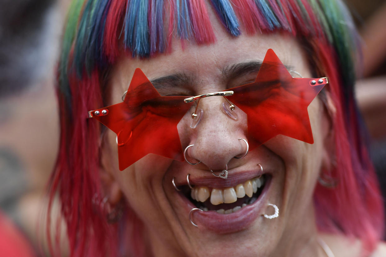 A woman wearing star-shaped glasses smiles during a campaign rally for former President Luiz Inacio Lula da Silva, who is running for the presidency again, in Sao Paulo, Brazil, Saturday, Oct. 29, 2022. On Sunday, Brazilians head to the voting booth again to choose between da Silva and incumbent Jair Bolsonaro, who are facing each other in a runoff vote after neither got enough support to win outright in the Oct. 2 general election. (AP Photo/Matias Delacroix)