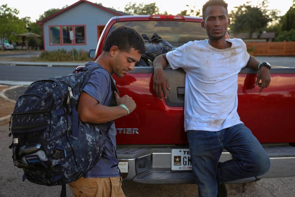 El migrante venezolano Irwign Gutiérrez, de 28 años, a la derecha, y su amigo Joryi Pérez, de 28 años, a la izquierda, completaron un día de trabajo. Los dos recogen sus objetos personales mientras esperan a ser transportados de vuelta al Centro de Recursos para Migrantes.