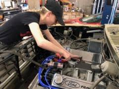 Kelly Ward, seen here in April 2024, torqueing the valve cover of a 1985 F-250 truck at her family's repair shop in Portland, Michigan.