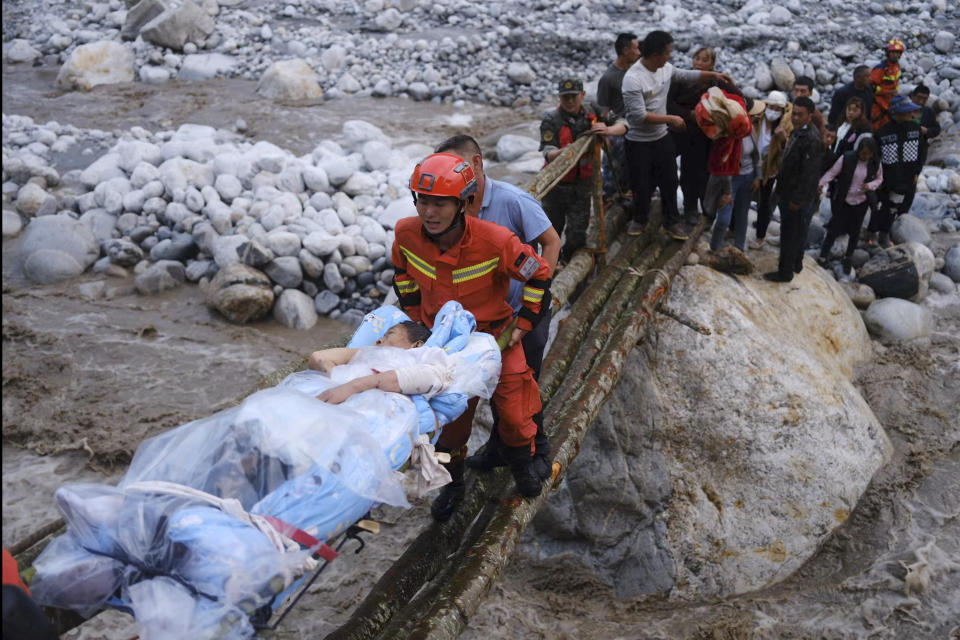 In this photo released by Xinhua News Agency, rescuers transfer survivors across a river following an earthquake in Moxi Town of Luding County, southwest China's Sichuan Province on Monday, Sept. 5, 2022. Dozens people were reported killed and missing in a 6.8 magnitude earthquake that shook China's southwestern province of Sichuan on Monday, triggering landslides and shaking buildings in the provincial capital of Chengdu, whose 21 million residents are already under a COVID-19 lockdown. (Cheng Xueli/Xinhua via AP)