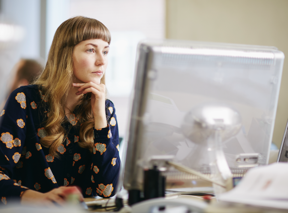 a woman in uniform looking at a computer monitor