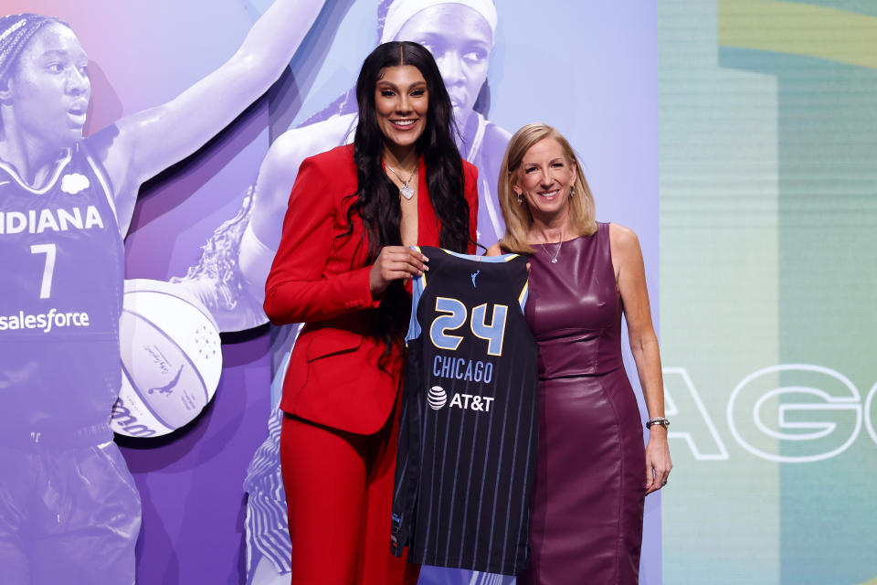 Kamilla Cardoso poses with WNBA Commissioner Cathy Engelbert in black strappy shoes.