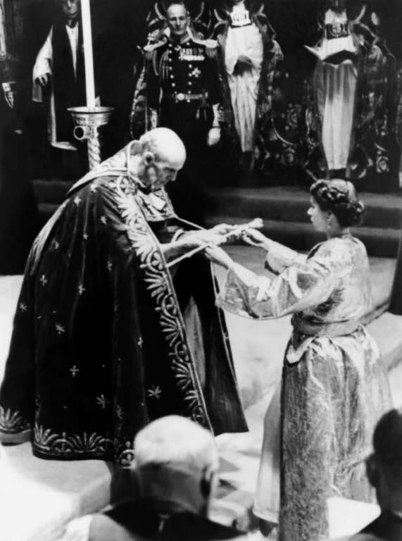 The Archbishop of Canterbury (L) gives Queen Elizabeth II a sword prior to her Coronation ceremony in Westminster Abbey in London on June 2, 1953