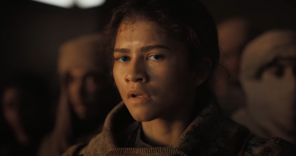 Close-up of an emotional Zendaya as Chani in "Dune," surrounded by others