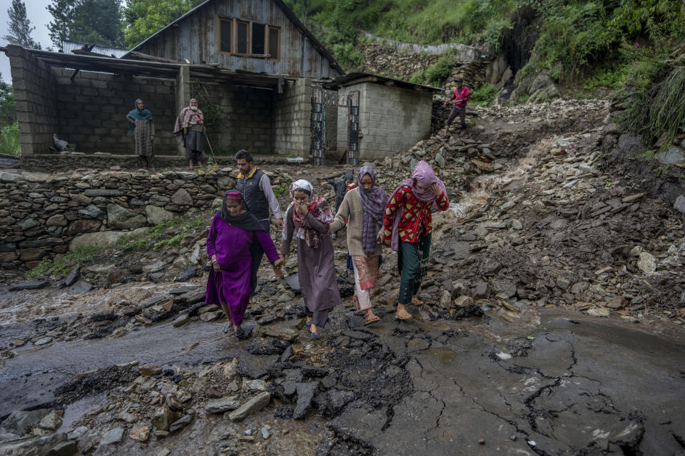 FILE - Kashmiri villagers walks on a road damaged by flash floods after a cloudburst on the outskirts of Srinagar, Indian controlled Kashmir, July 22, 2023. Such intense rainfall events, especially when more than 10 centimeters (3.94 inches) of rainfall occurs within a 10 square kilometers (3.86 square miles) region within an hour are called cloudbursts and have potential to wreak havoc, causing intense flooding and landslides that affect thousands in mountain regions. (AP Photo/Dar Yasin, File)