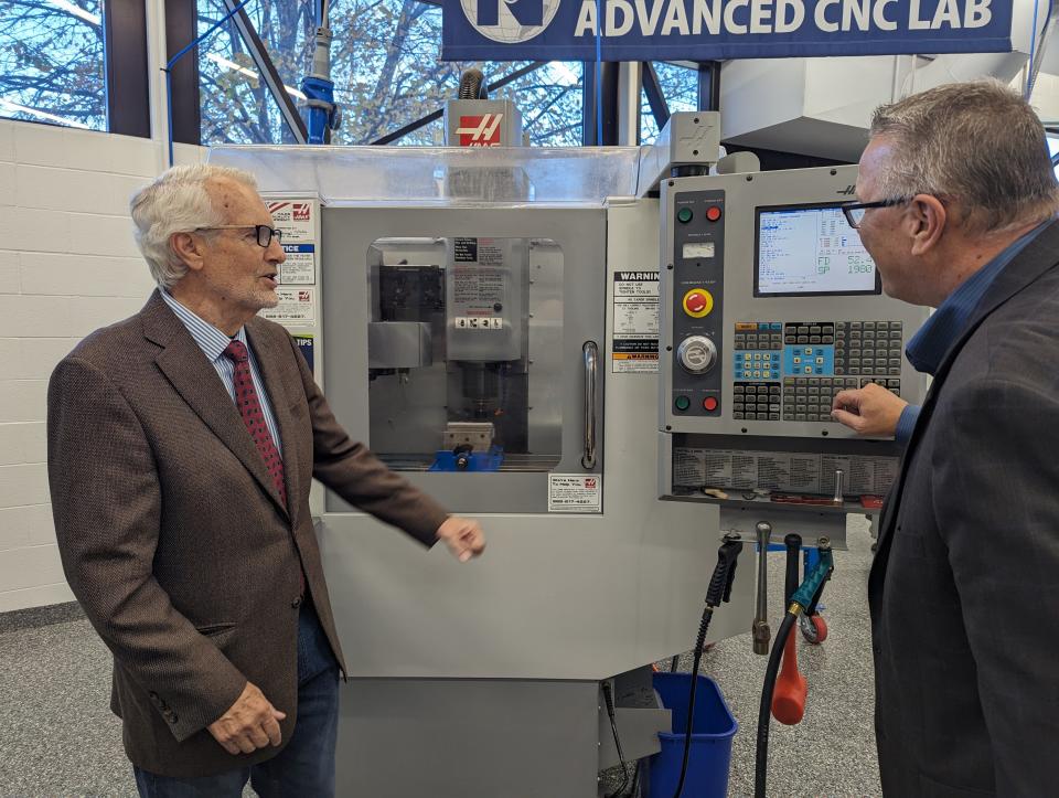 Andrew Kalnow, left, CEO of National Machinery of Tiffin, describes to Terra State University President Ronald Schumacher the many uses for one of the new CNC metal fabrication machines his company helped to fund.