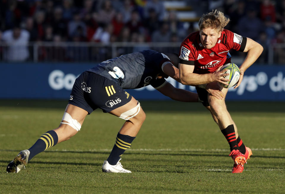 Crusaders Jack Goodhue, right, attempts to break the tackle of Highlanders Marino Mikaele-Tu'u during the Super Rugby Aotearoa rugby game between the Crusaders and the Highlanders in Christchurch, New Zealand, Sunday, Aug. 9, 2020. (AP Photo/Mark Baker)