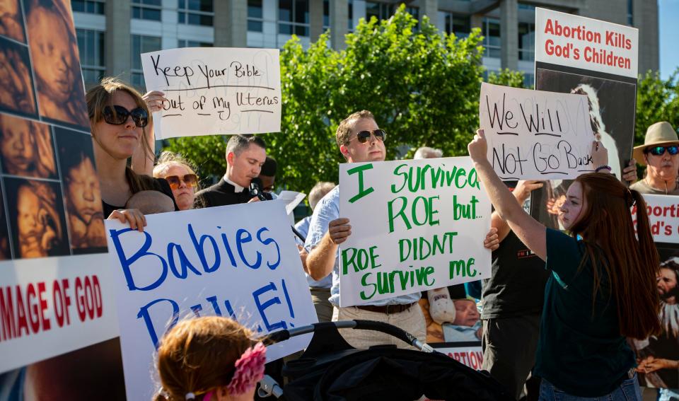 Anti-abortion and abortion-rights protesters hold signs up in front of each other on Friday, June 24, 2022, outside of the Stanley J. Roszkowski United States Courthouse in Rockford.