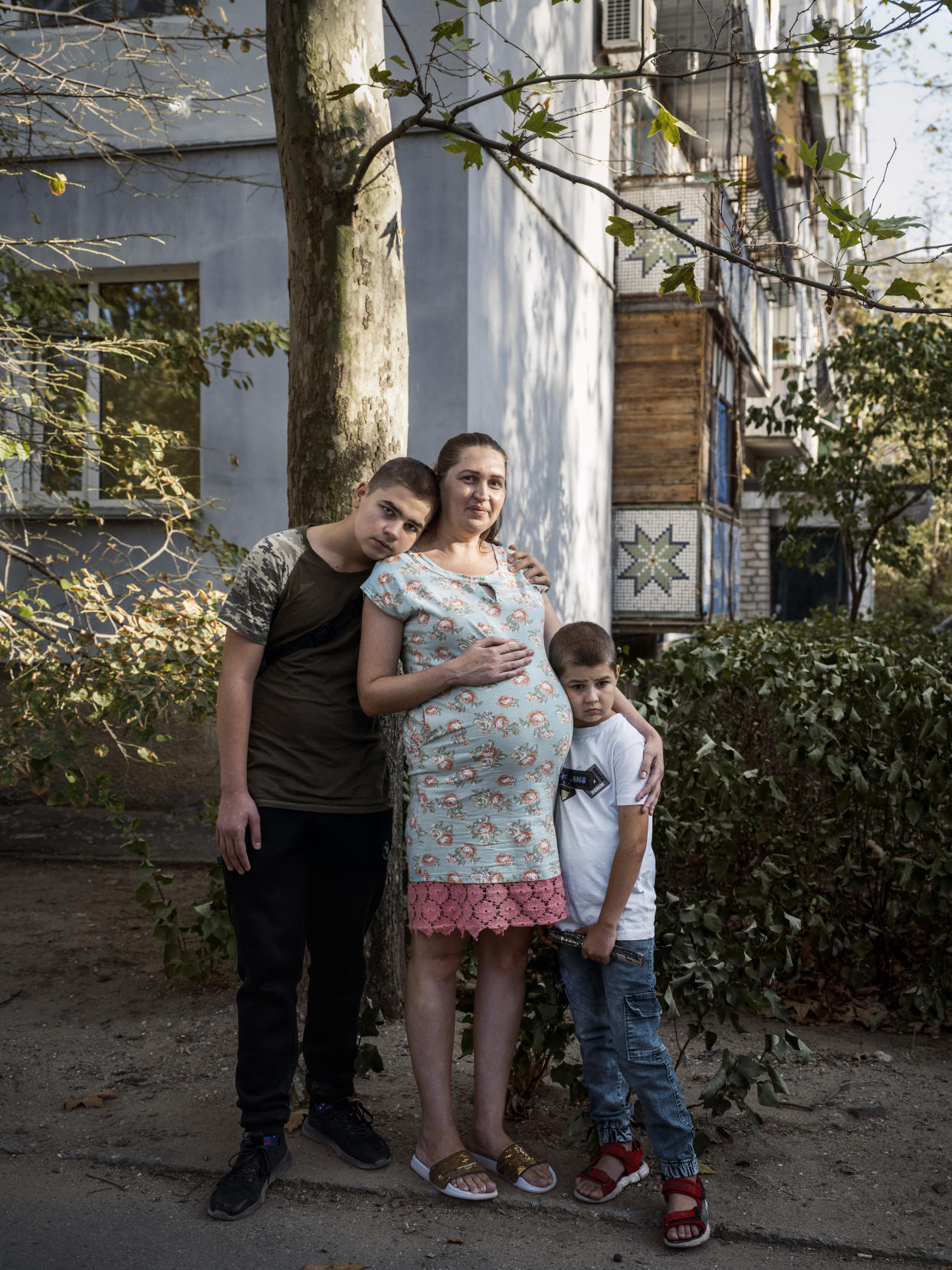 Dmytro Klymenko, de 14 años, con su madre, Yana, y su hermano, Volodymyr, de 8, en Nicolaiev, Ucrania, el 5 de octubre de 2023. (Daniel Berehulak/The New York Times)
