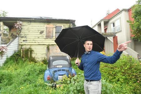 Emeryville Vice-Mayor John Bauters gestures in front of a neglected property in Emeryville, California, United States March 20, 2017. REUTERS/Noah Berger