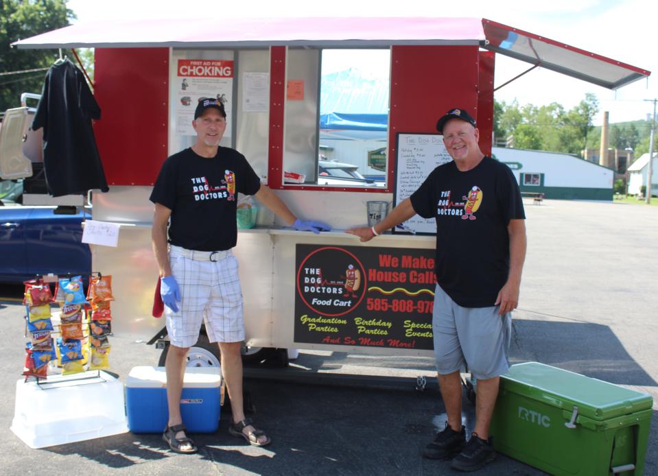 Tim Smith, left, and Thane Graves recently retired from teaching careers at Scio Central School and have launched a new food cart business, The Dog Doctors. The duo set up in Belmont Wednesday.
