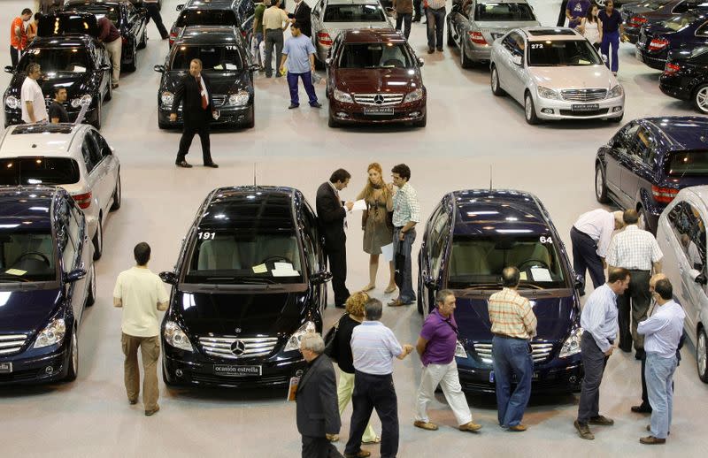 FILE PHOTO: People take a look at second-hand cars at a second-hand car fair in Madrid