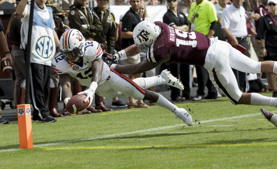 Auburn wide receiver Eli Stove (12) dives for the end zone for a touchdown as Texas A&M linebacker Anthony Hines III (19) defends during the second half of an NCAA college football game on Saturday, Nov. 4, 2017, in College Station, Texas. (AP Photo/Sam Craft)