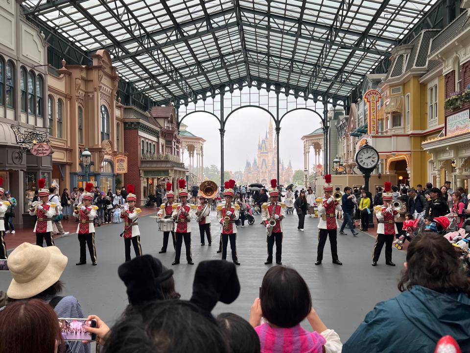 Guests stop to enjoy the music at World Bazaar in Tokyo Disneyland.