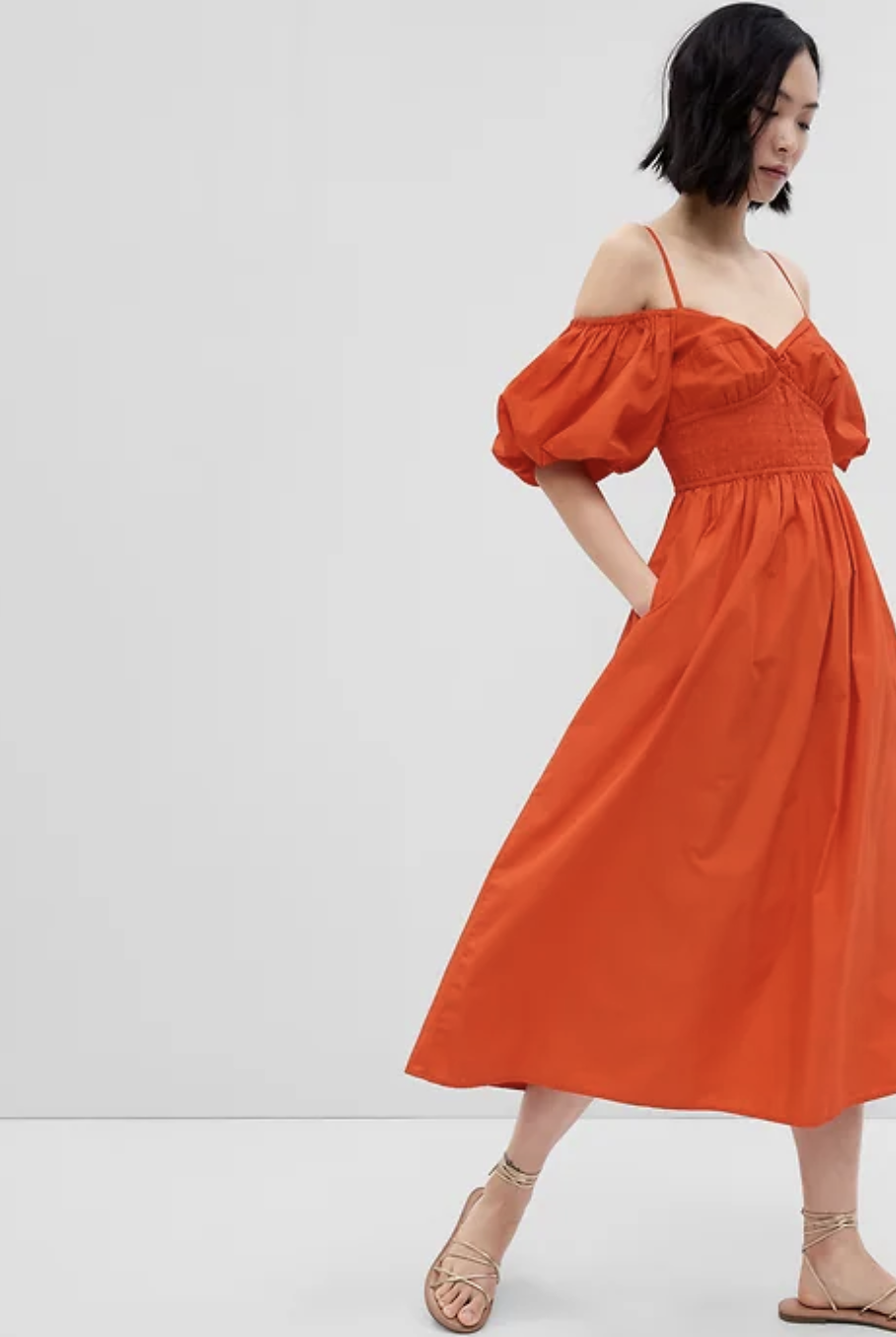 asian model wearing orange midi dress, Off-Shoulder Puff Sleeve Maxi Dress in lava orange (photo via Gap)