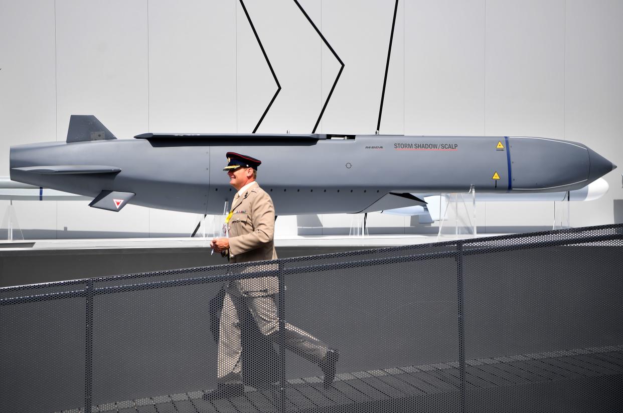 A member of the military walks past a MBDA Storm Shadow/Scalp missile 