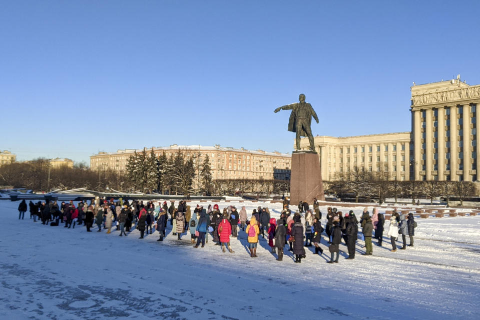 People gather for a flashmob in support of Russian President Vladimir Putin at a Vladimir Lenin in St. Petersburg, Russia, Monday, Feb. 8, 2021. Kremlin-backed media reported that a grassroots flashmob titled "Putin is our president" started sweeping the country. State news channel Rossiya 24 aired videos from different cities of people dancing to patriotic songs and waving Russian flags, describing them as a genuine expression of support for Putin. (AP Photo)