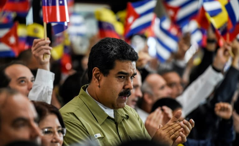 Venezuelan President Nicolas Maduro applauds during a ceremony honouring Cuban leader Fidel Castro one day after Castro's death, in Caracas, on November 26, 2016