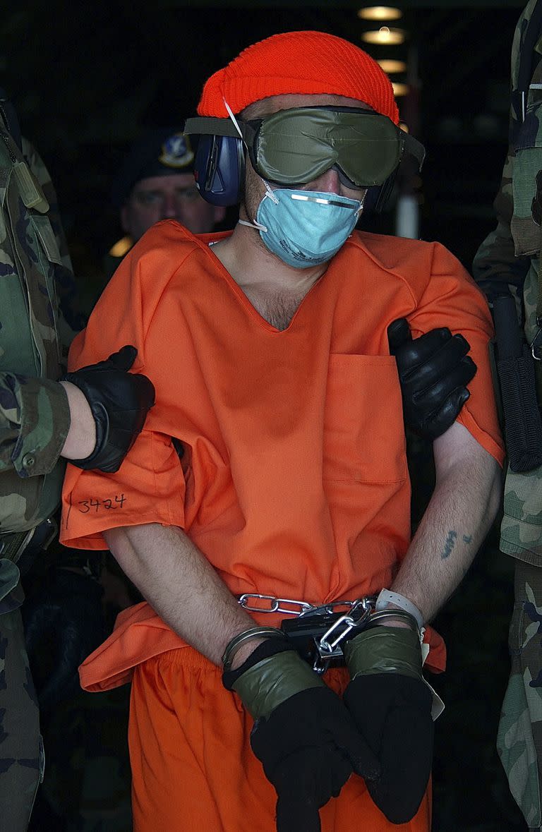 En una imagen proporcionada por la Fuerza Aérea, David Hicks, un australiano que fue capturado luchando para los talibanes, es conducido desde un avión de carga en el primer día de operaciones de la prisión en la Bahía de Guantánamo en Cuba, el 11 de enero de 2002.