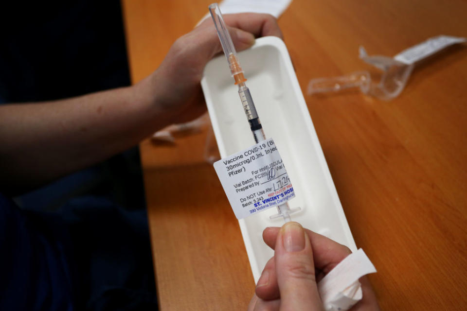 A staff member holds a Pfizer vaccine prepared for clients at the St Vincent's Covid-19 Vaccination Clinic in Sydney, Australia.