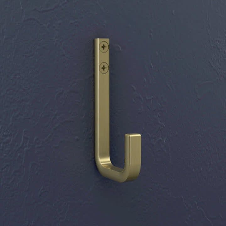 gold hook nailed to dark navy blue wall