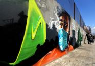 A Lebanese policeman walks past graffiti denouncing the ongoing trash crisis in Beirut on August 28, 2015