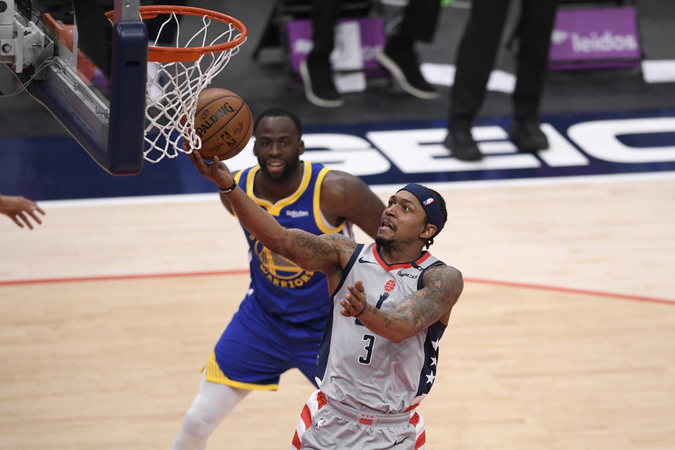 Washington Wizards guard Bradley Beal (3) goes to the basket past Golden State Warriors forward Draymond Green, back, during the first half of an NBA basketball game, Wednesday, April 21, 2021, in Washington. (AP Photo/Nick Wass)