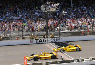FILE - In this May 25, 2014, file photo, Ryan Hunter-Reay celebrates after crossing the finish line, taking the checkered flag in front of Helio Castroneves, of Brazil, to win the 98th running of the Indianapolis 500 IndyCar auto race at the Indianapolis Motor Speedway in Indianapolis. The Associated Press has updated its survey of living Indianapolis 500 winners and their pick as the greatest race in the long history of the event. There are six races that received multiple votes, topped by Al Unser Jr.’s victory over Scott Goodyear in 1992 — the closest Indy 500 in history. The others are Emerson Fittipaldi's win in 1989; Sam Hornish Junior's win in 2006; the 1982 battle between Rick Mears and Gordon Johncock; the 2011 race won by the late Dan Wheldon; and the 2014 thriller won by Hunter-Reay. (AP Photo/Dave Parker, File)