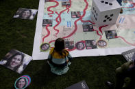 Gabriella, the seven year old daughter of imprisoned British-Iranian Nazanin Zaghari-Ratcliffe joins in a game on a giant snakes and ladders board in Parliament Square, London, to show the "ups and downs" of Zaghari-Ratcliffe's case to mark the 2,000 days she has been detained in Iran, Thursday, Sept. 23, 2021. Zaghari-Ratcliffe was originally sentenced to five years in prison after being convicted of plotting the overthrow of Iran's government, a charge that she, her supporters and rights groups deny. While employed at the Thomson Reuters Foundation, the charitable arm of the news agency, she was taken into custody at the Tehran airport in April 2016 as she was returning home to Britain after visiting family. (AP Photo/Matt Dunham)